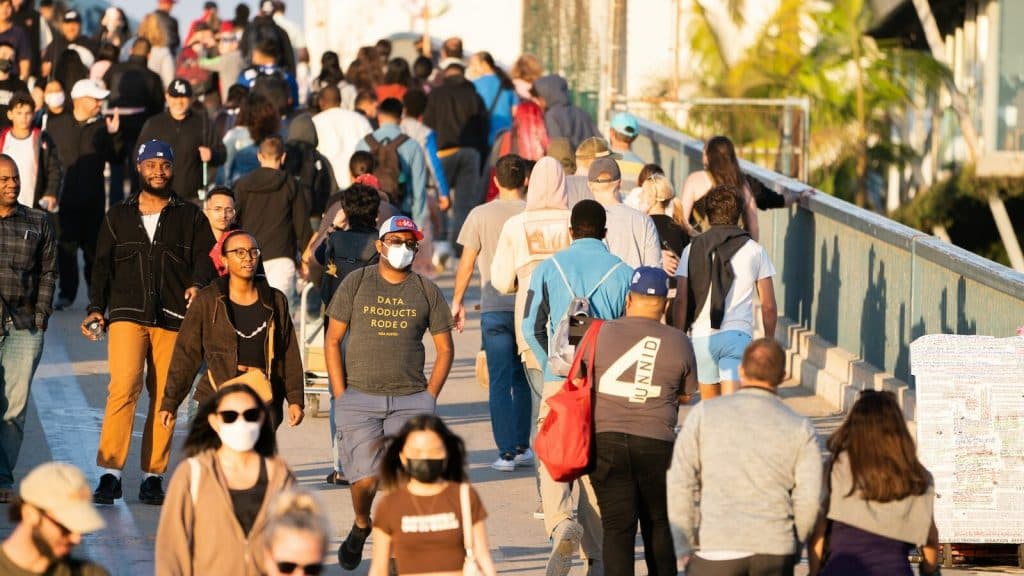 a large group of people walking down a sidewalk