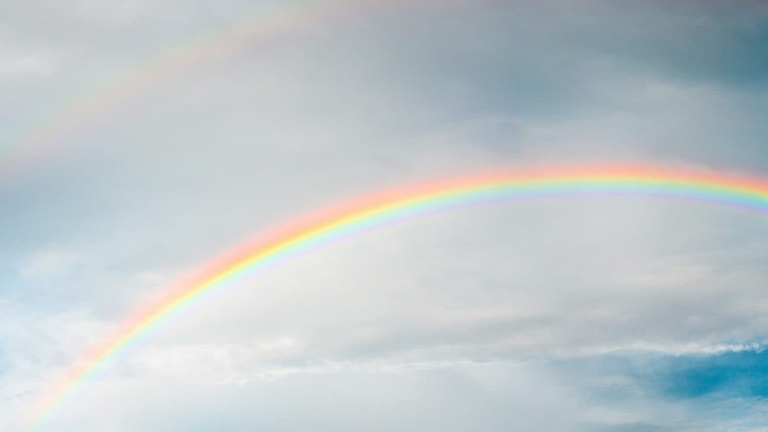 rainbow under cloudy sky during daytime