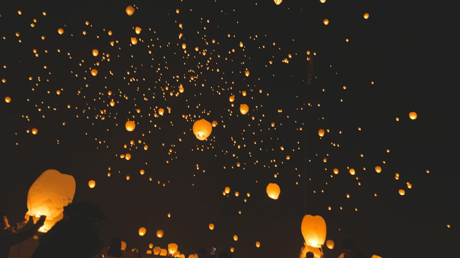 people raising sky lanterns